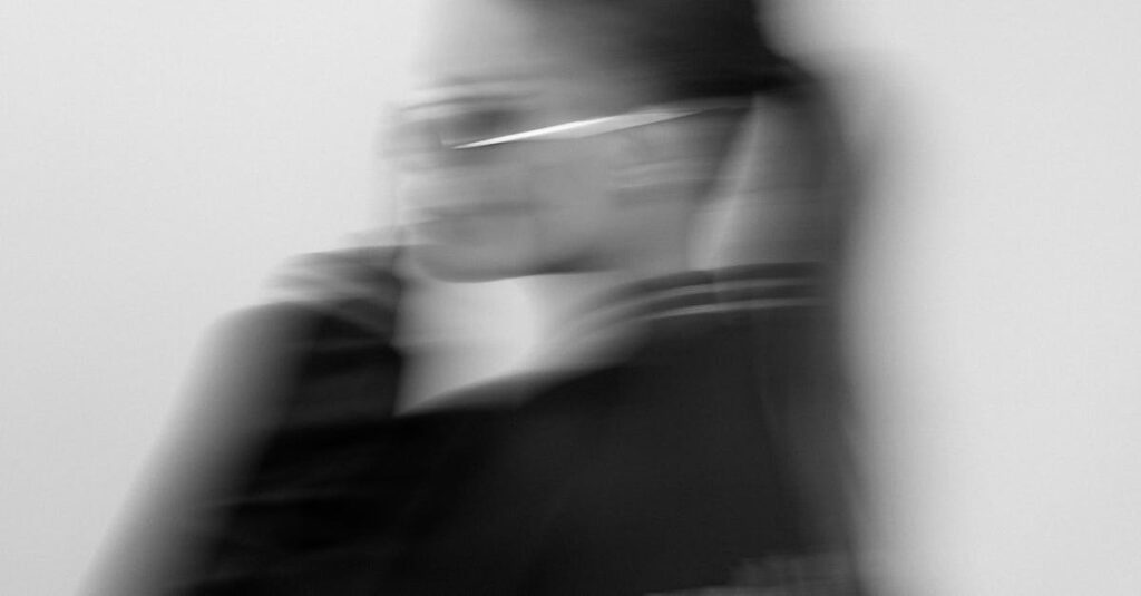 Stylized blurred monochrome portrait of a woman in sunglasses, defocusing artistic effect.