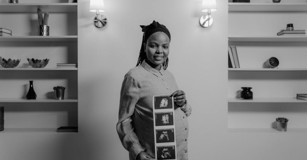 Monochrome image of a pregnant woman holding ultrasound pictures, showcasing joyful anticipation.