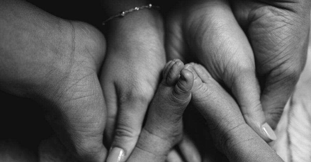 A touching black and white photo of a family holding hands, symbolizing unity and love.