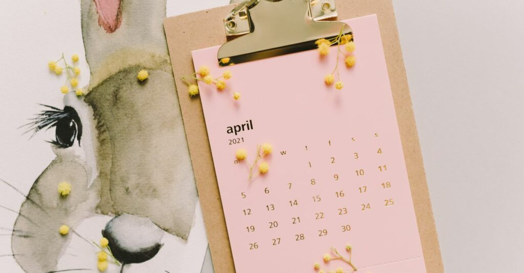 April 2021 calendar with watercolor bunny and mimosa flowers on clipboard.