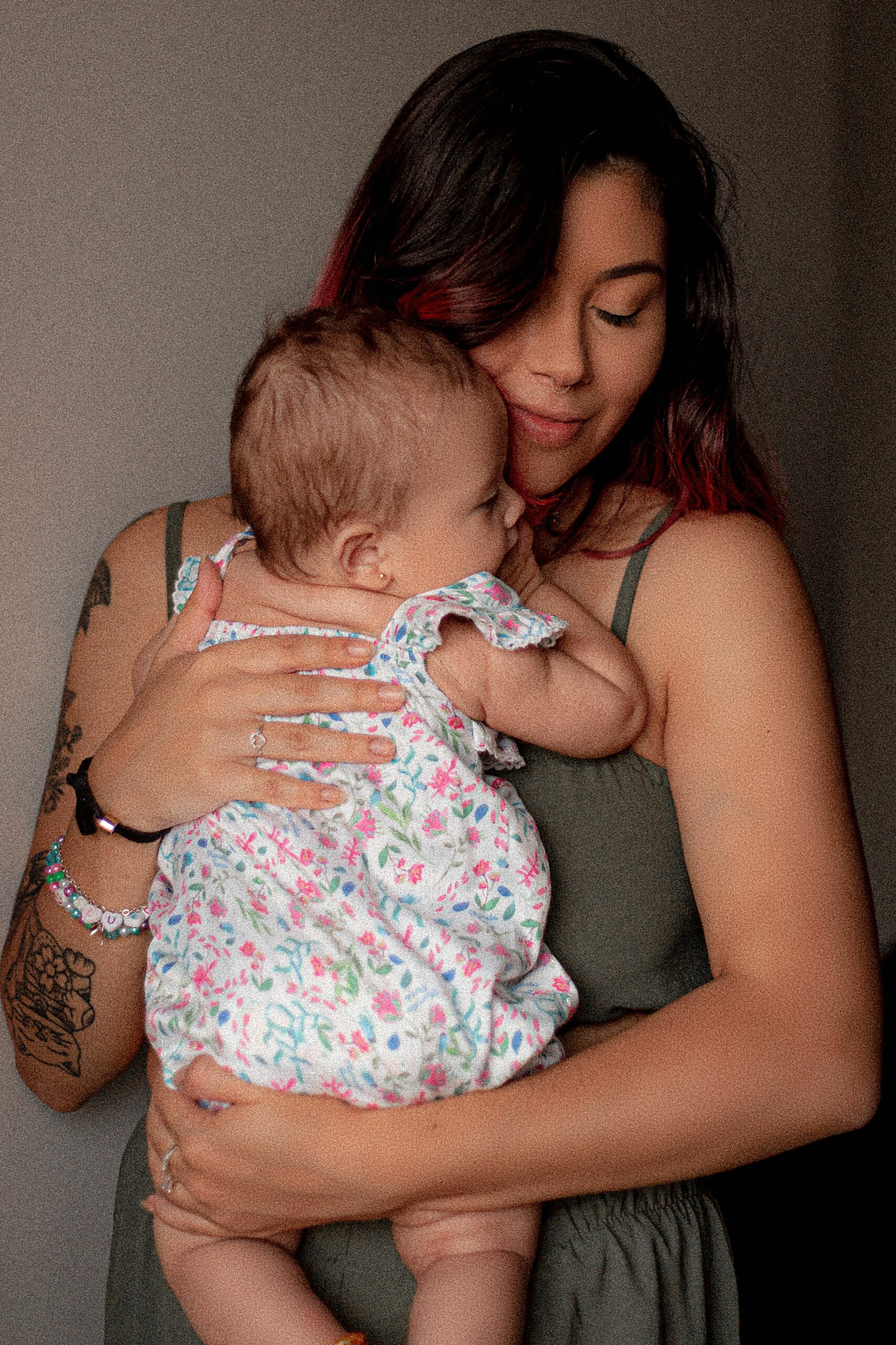 A tender moment capturing a mother holding her baby with love and affection indoors.